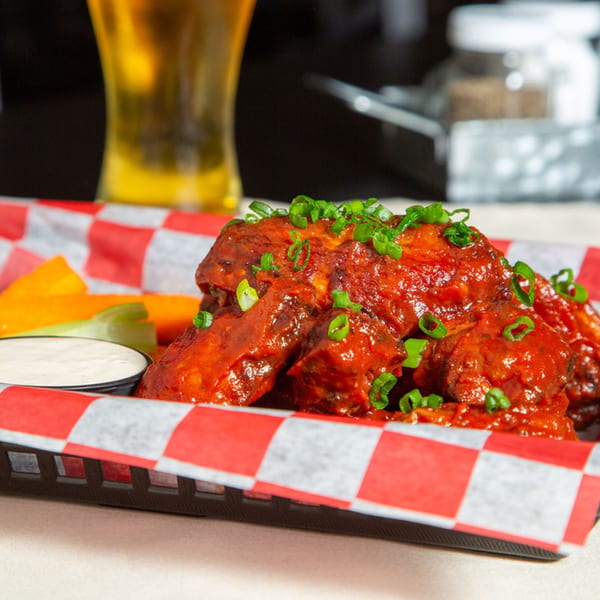 Red Barn Restaurant's spicy chicken wings with green onions, celery, carrots, and ranch dressing.